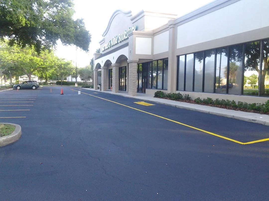 A well-maintained concrete sidewalk leading to a Tampa commercial building with an asphalt parking lot